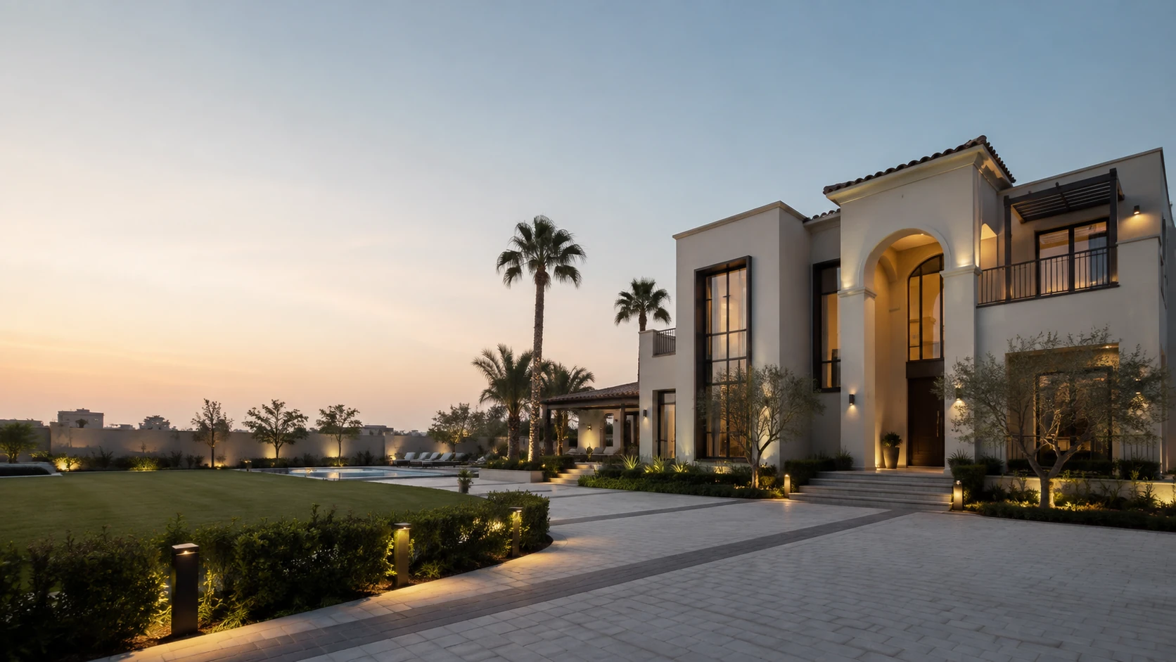A premium detached Dubai villa with a double-height arched entrance, mature palms and landscaped grounds photographed at dusk